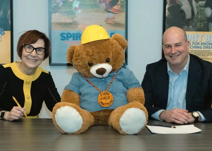 Cindy Blackstock, Gitxsan and Caring Society Executive Director with François Vachon, President and CEO, Colas Canada Inc. seen with Spirit Bear while signing the partnership agreement.