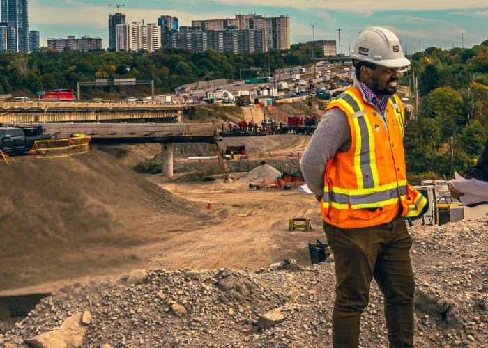 A male and female team member from The Miller Group reviewing documents standing over the Highway 401 Rehabilitation project. 