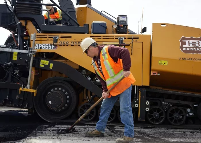 A Miller Group team member spreading fresh asphalt