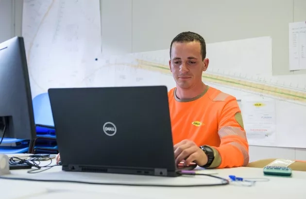 Un employé de Colas qui regarde son écran d'ordinateur