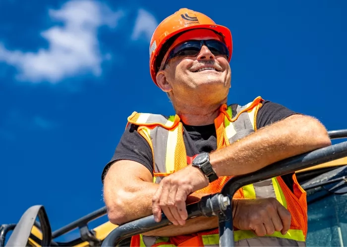Colas Quebec employee looks over a project from a machine. 