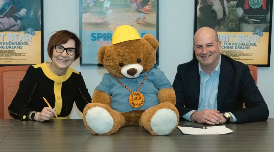 Cindy Blackstock, Gitxsan and Caring Society Executive Director with François Vachon, President and CEO, Colas Canada Inc. seen with Spirit Bear while signing the partnership agreement.