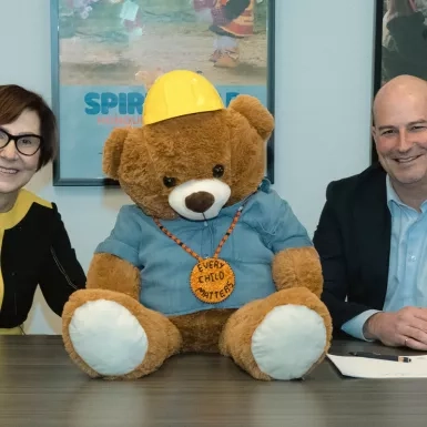 Cindy Blackstock, Gitxsan and Caring Society Executive Director with François Vachon, President and CEO, Colas Canada Inc. seen with Spirit Bear while signing the partnership agreement.