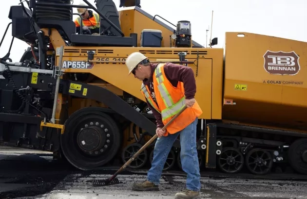 A Miller Group team member spreading fresh asphalt