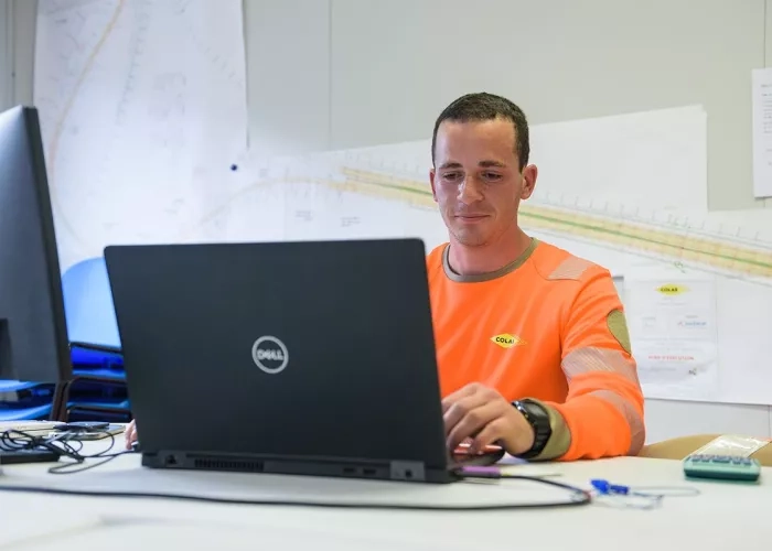 Un employé de Colas qui regarde son écran d'ordinateur