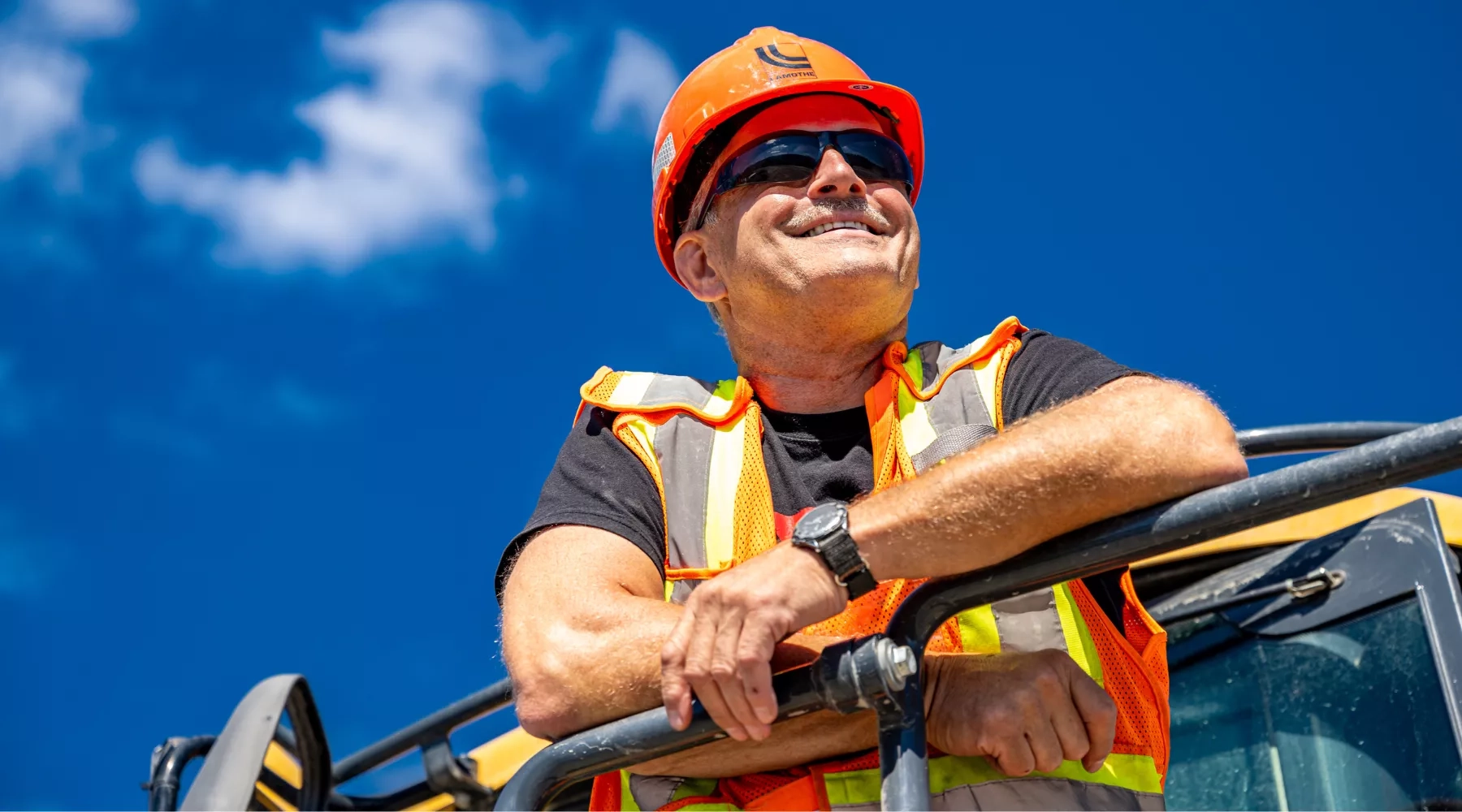 Colas Quebec employee looks over a project from a machine. 