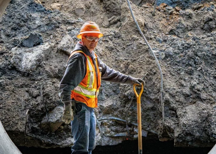 Colas Quebec employee stands inside large pipe while completing an underground works project. 