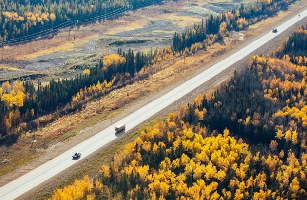 Arial view of crews completing work on the Highway 33 project with scenic forests and fall colours on both sides of the highway.