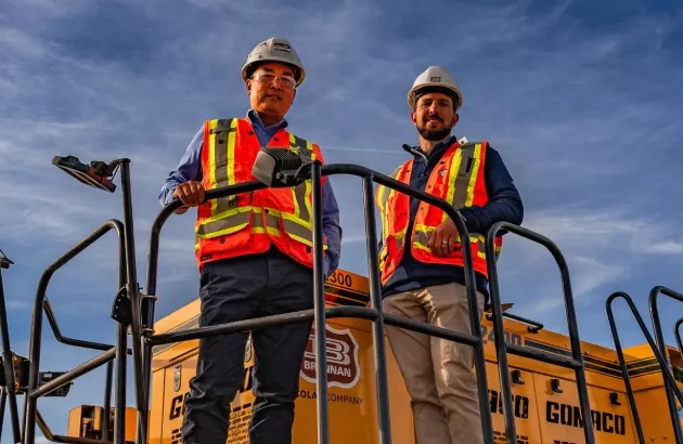 View of team members from the Miller Group standing with their vehicle. 