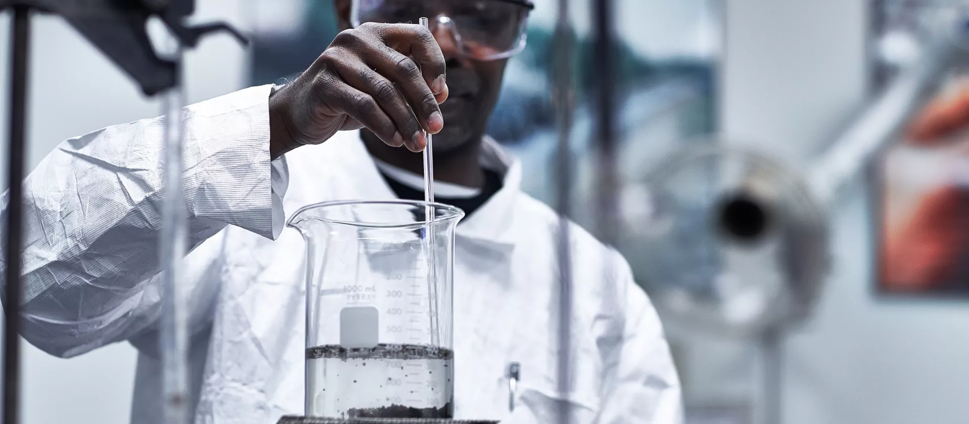 McAsphalt team member takes a sample of liquid for testing. 