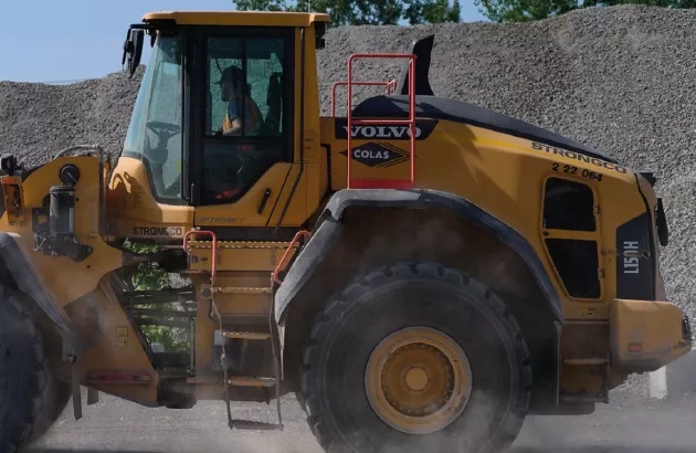 A truck drives by recycled materials at Colas Québec's Kirkland facility
