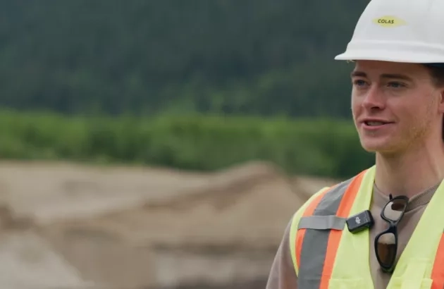 An employee of Colas Western Canada Inc. company Terus stands in front of a rehabilitated gravel pit.