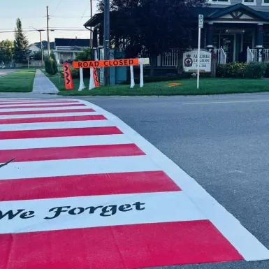Photo of the competed Veteran's crosswalk, featuring the silhouette of a soldier and phrase "Lest We Forget"